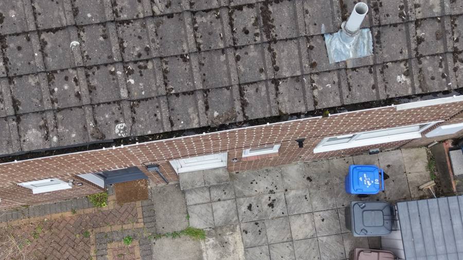 Drone view of blocked gutter with moss and debris build-up